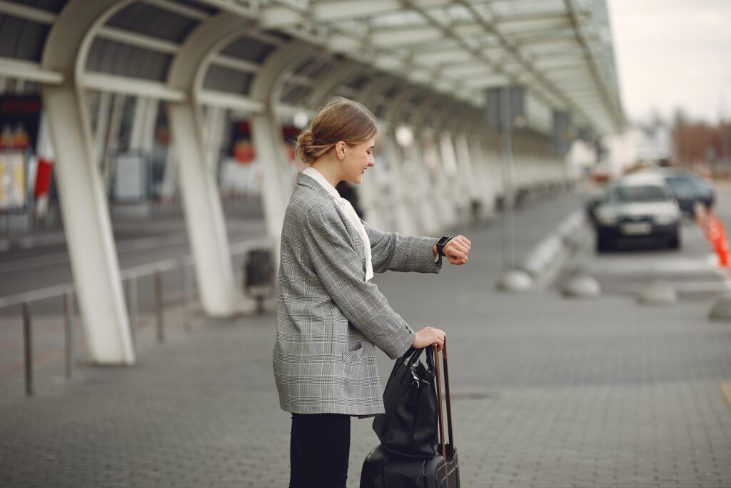 woman with suitcase standing by airport