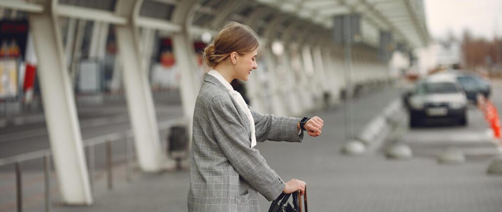 woman with suitcase standing by airport